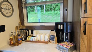 A kitchen with a coffee bar sign, coffee maker, coffee cups, honey, syrup, and a coffee bean bag. - Mississippi River view. Duck Hunters Get away. 4 Bedroom, 5 bed - Sleeps 10. (Brownsville)