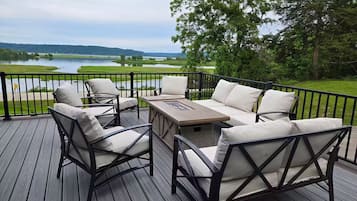 A deck with outdoor furniture and a view of a lake.