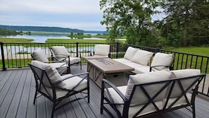 A deck with outdoor furniture and a view of a lake.