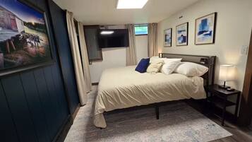 Une chambre à coucher avec un lit, une télévision, un bureau et une lampe.