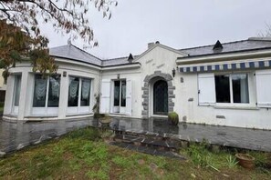 A two-story building with a central entrance, large windows, and a paved courtyard. - Les Sylphes - Parking, WiFi, TV, 350m to the beach (Pornichet)