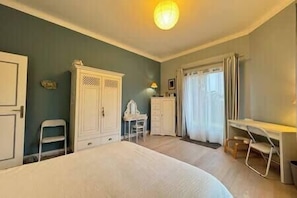 A bedroom with a bed, a desk, and a wardrobe. - Les Sylphes - Parking, WiFi, TV, 350m to the beach (Pornichet)