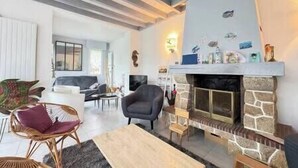 Ein Wohnzimmer mit Kamin, Sitzecke und Fernseher.