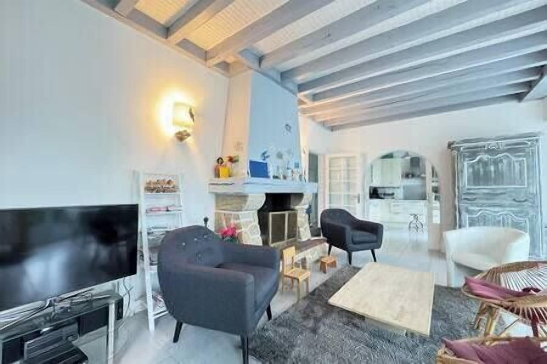 Una sala de estar moderna con televisor de pantalla plana, chimenea y comedor con mesa y sillas.