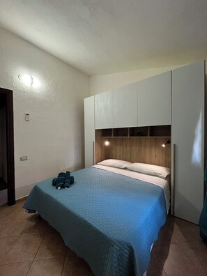 A bedroom with a bed, a wardrobe, and a nightstand. - Villa Aurea House with Garden, Vico Andrea Doria Bassa 8 (Costa Rei)
