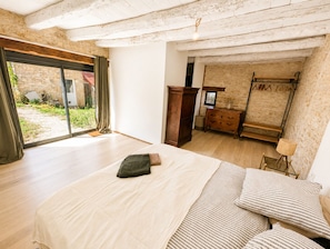 A bedroom with a large bed, a wardrobe, and a mirror.
