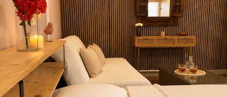 A hotel room with a bed, bedside table, and a mirror.