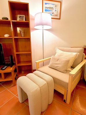 A room with a bed, a bedside lamp, a wooden shelf unit, and a television on a stand. - Fantastic Apartment: " Azul " in Tavira, with a garden terrace and swimming pool (Tavira)