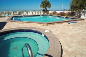 A swimming pool with a tiled edge and a small hot tub. - Top Floor Gulf Front • Pool • Sand Castle North 503 (Indian Rocks Beach)