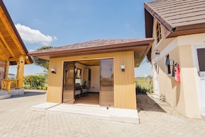 A wooden structure with a door labeled 'OFFICE' leading into a room with a chair and a table.