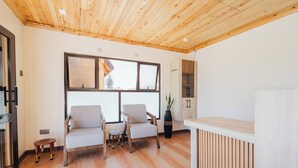 Un interior moderno con piso de madera, dos sillones, una mesita, un armario y un radiador.