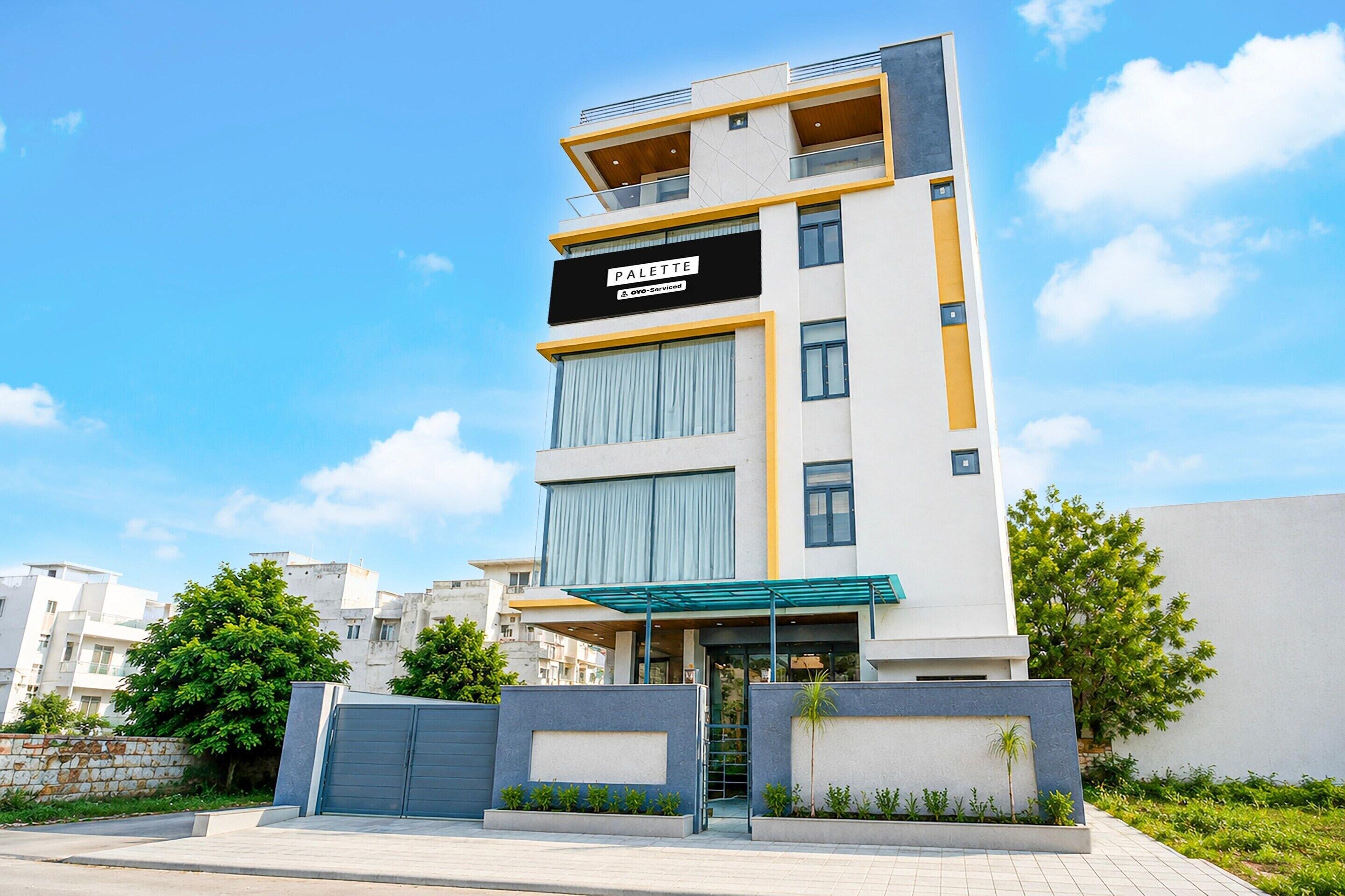 Un edificio de varios pisos con un letrero que dice 'PALETTE' y 'OVO-Serviced'.