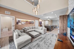 Een moderne woonkamer met een modulaire bank, een salontafel en een flatscreen televisie.