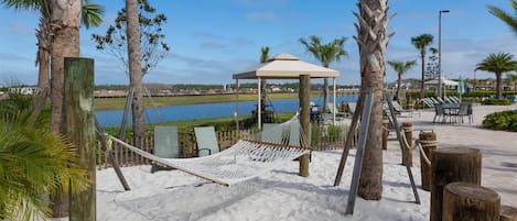Unwind in the cozy hammock between palm trees, surrounded by soft white sand and tranquil water views. This serene outdoor spot is perfect for enjoying a gentle breeze and soaking up the sunshine.