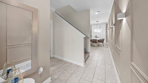 A hallway with a staircase, a dining area, and a bathroom with a toilet and a shower. - 4BR house sleeps 8 with private pool (Kissimmee)