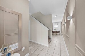 A hallway with a staircase, a dining area, and a bathroom with a toilet and a shower. - 4BR house sleeps 8 with private pool (Kissimmee)