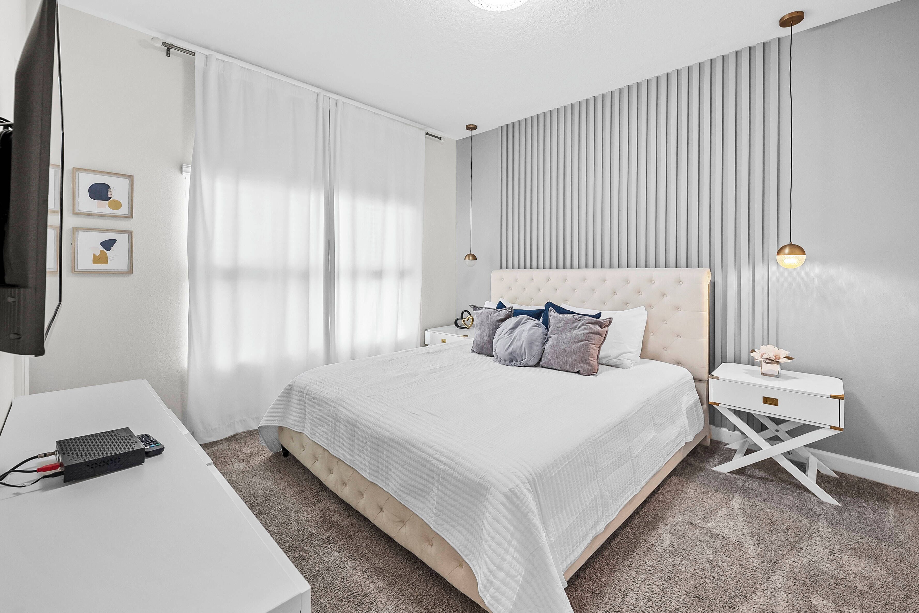 Une chambre d’hôtel avec un lit, un bureau, une télévision et une table de chevet.