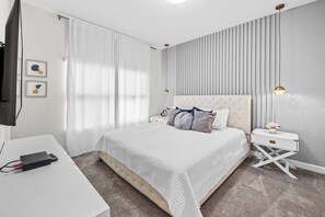 A hotel room with a bed, a desk, a TV, and a nightstand. - 4BR house sleeps 8 with private pool (Kissimmee)