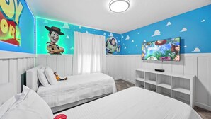 A bedroom with two beds, a TV, and a wall with a blue sky design. - 4BR house sleeps 8 with private pool (Kissimmee)