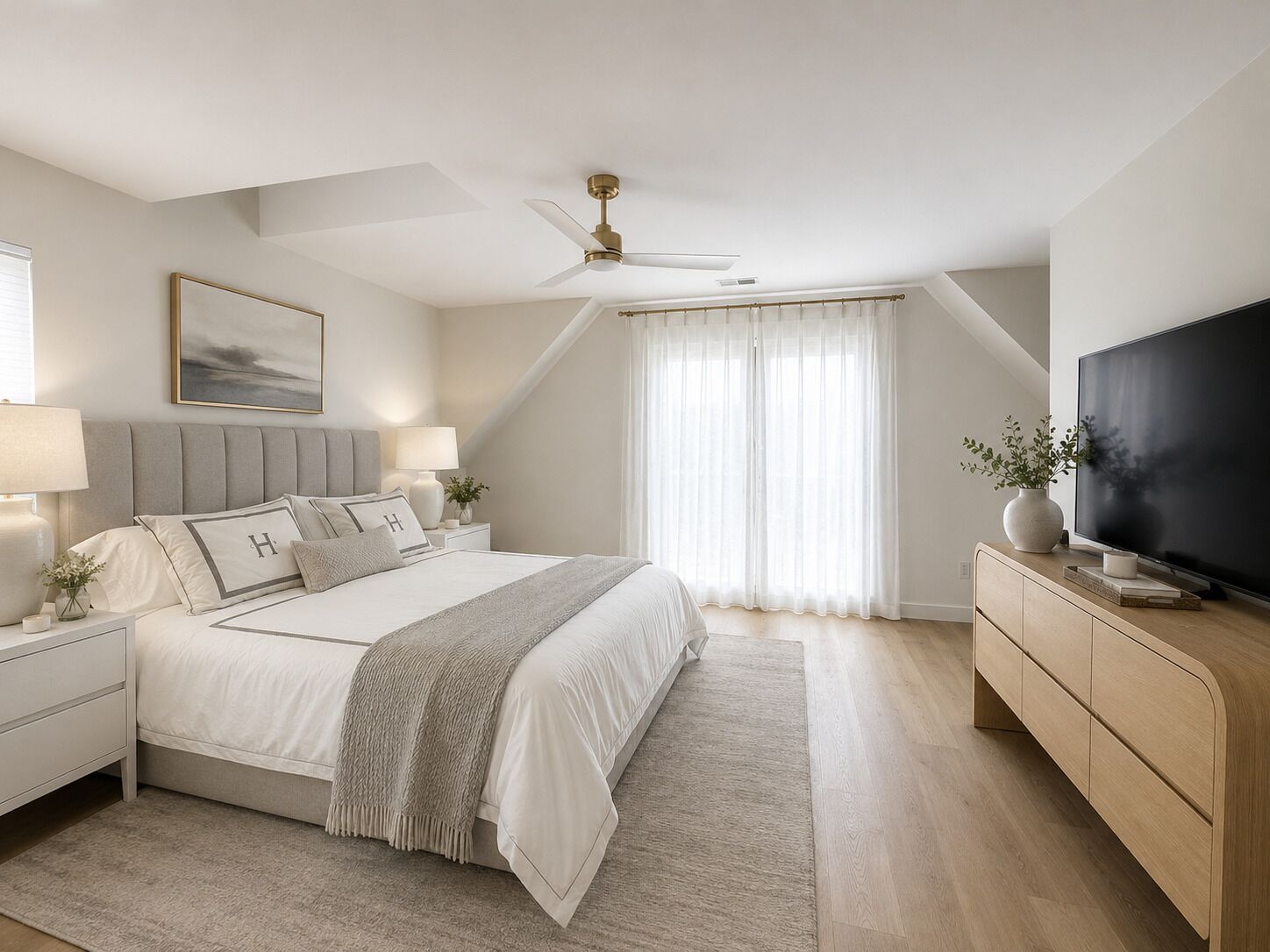 A bedroom with a bed, nightstands, a television, a ceiling fan, and a window with curtains.