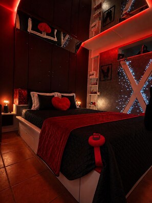 A bedroom with a bed, bedside tables, and wall-mounted shelves. - Secret Room & Spa (Les Trois-Îlets)