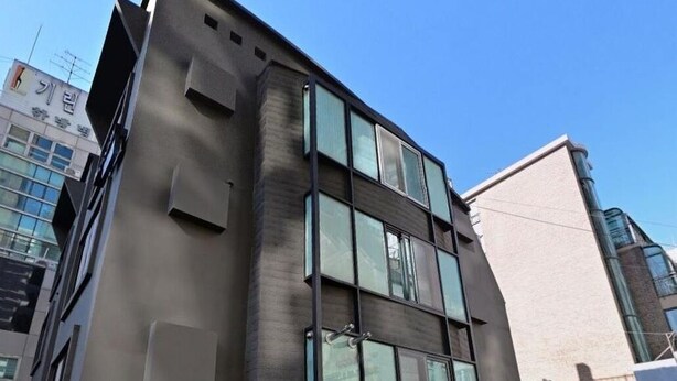 Ein mehrgeschossiges Gebäude mit modernem architektonischen Design, das große Fenster und eine flache Fassade aufweist.