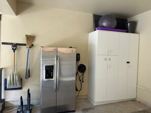 A kitchen with a stainless steel refrigerator, a white cabinet, and a broom hanging on the wall. - 1491 April Mountain Drive (Park City)