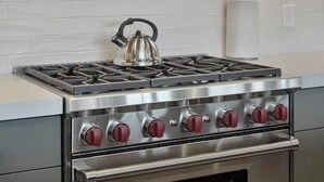 A stainless steel stove with four burners and a kettle on top. - 1491 April Mountain Drive (Park City)