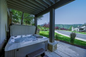 A hot tub under a covered patio with a view of a residential street and hills. - 1491 April Mountain Drive (Park City)