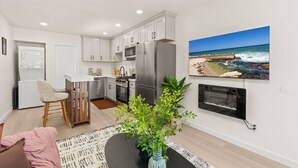A modern kitchen with white cabinets, a stainless steel refrigerator, and a built-in oven. - Walk to Beach (3 Blks)! 2BR/2-Beds PB Gem + AC - Holiday Home (San Diego)