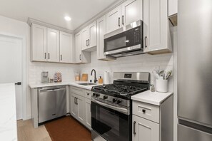 A modern kitchen with stainless steel appliances, white cabinetry, and a built-in microwave. - Walk to Beach (3 Blks)! 2BR/2-Beds PB Gem + AC - Holiday Home (San Diego)