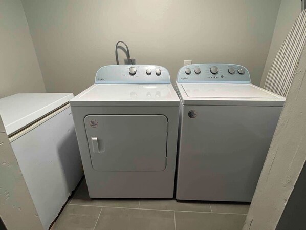 A laundry room with two stacked washers and a dryer.