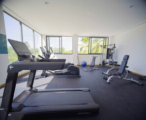 Ein Fitnessstudio mit Laufbändern, Gymnastikbällen und Krafttrainingsgeräten.