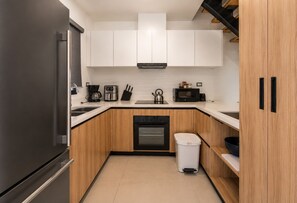 A compact kitchen with a refrigerator, stove, microwave, and coffee maker. - BORN Villa Laguna Vista Is Your Home Away From Home in Paradise! (Punta Cana)