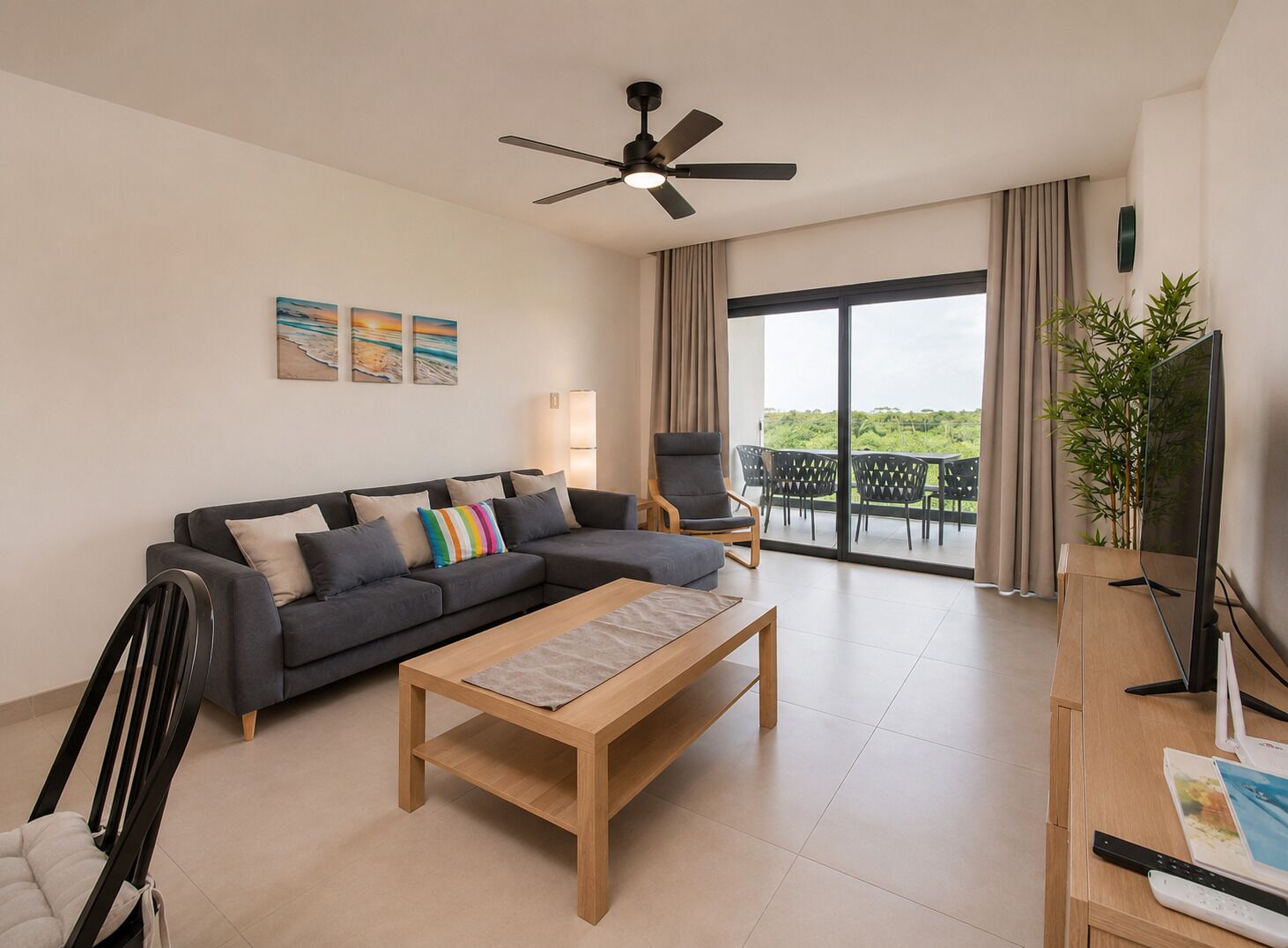 A modern living room with a sofa, coffee table, and a balcony with outdoor furniture.