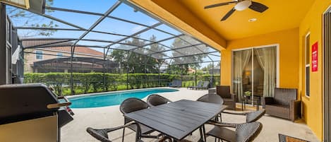 Ein überdachter Außenbereich mit Pool, Tisch und Stühlen.