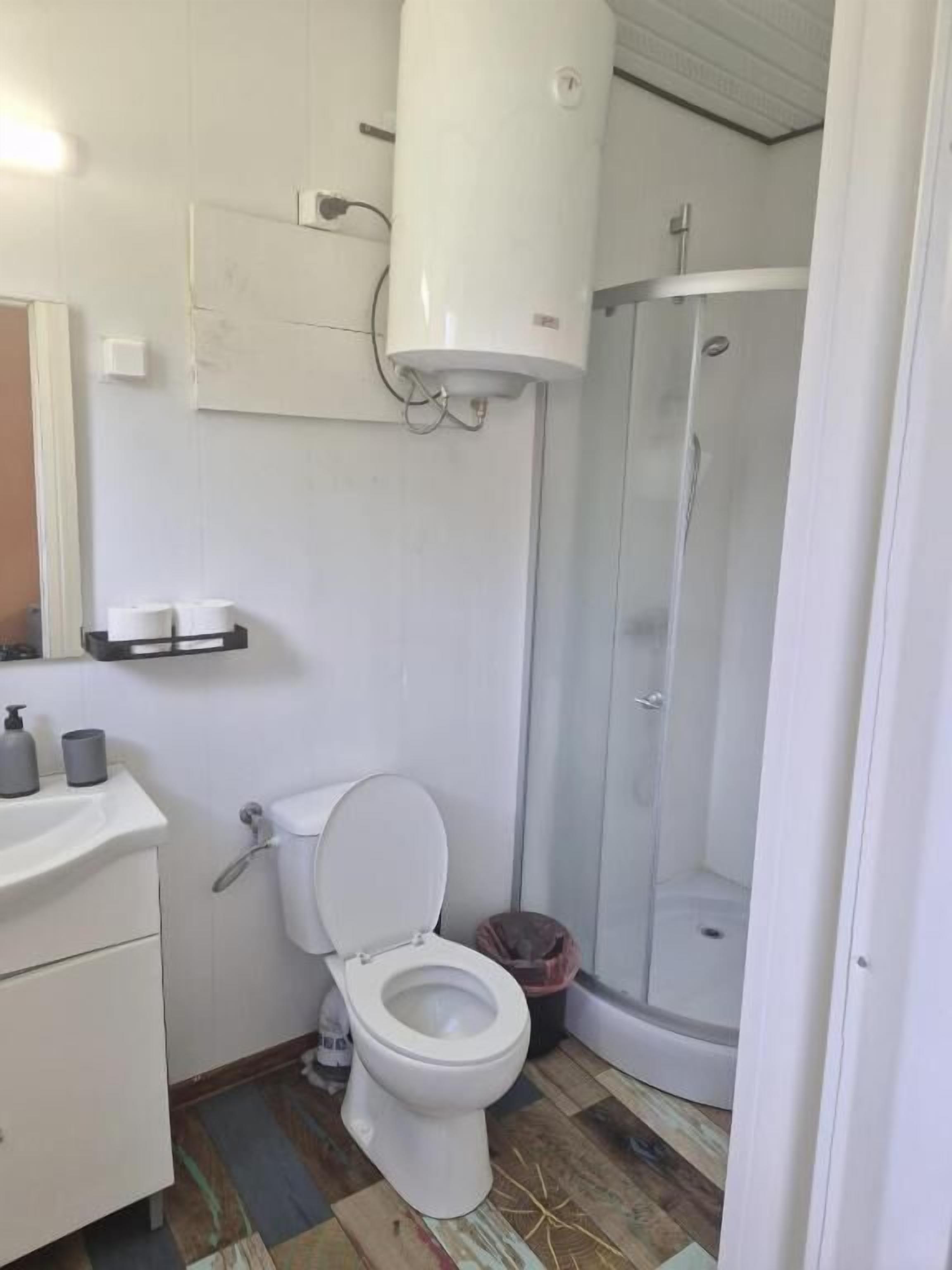 A bathroom with a toilet, sink, and shower.