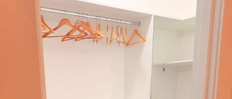 A walk-in closet with open shelves and a clothing rack.