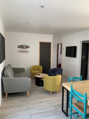 A modern living room with a sofa, armchairs, a coffee table, and a dining table with chairs. - Fenced detached house 600m from the sea (La tranche sur mer)