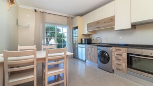 A modern kitchen with a built-in oven, microwave, and dishwasher. - Casa Vista Mar - 2 Bed Apt With Sea Views & Communal Pool (Carvoeiro)