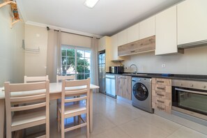 A modern kitchen with a built-in oven, microwave, and dishwasher. - Casa Vista Mar - 2 Bed Apt With Sea Views & Communal Pool (Carvoeiro)