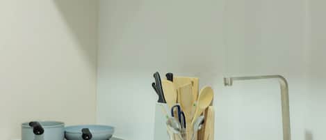 A kitchen with a double sink, a microwave, and a utensil holder.