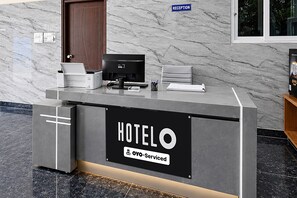A hotel reception desk with a sign reading 'HOTELO & OYO-serviced'. - Hotel Gachibowli Formerly Astra (Hyderabad)