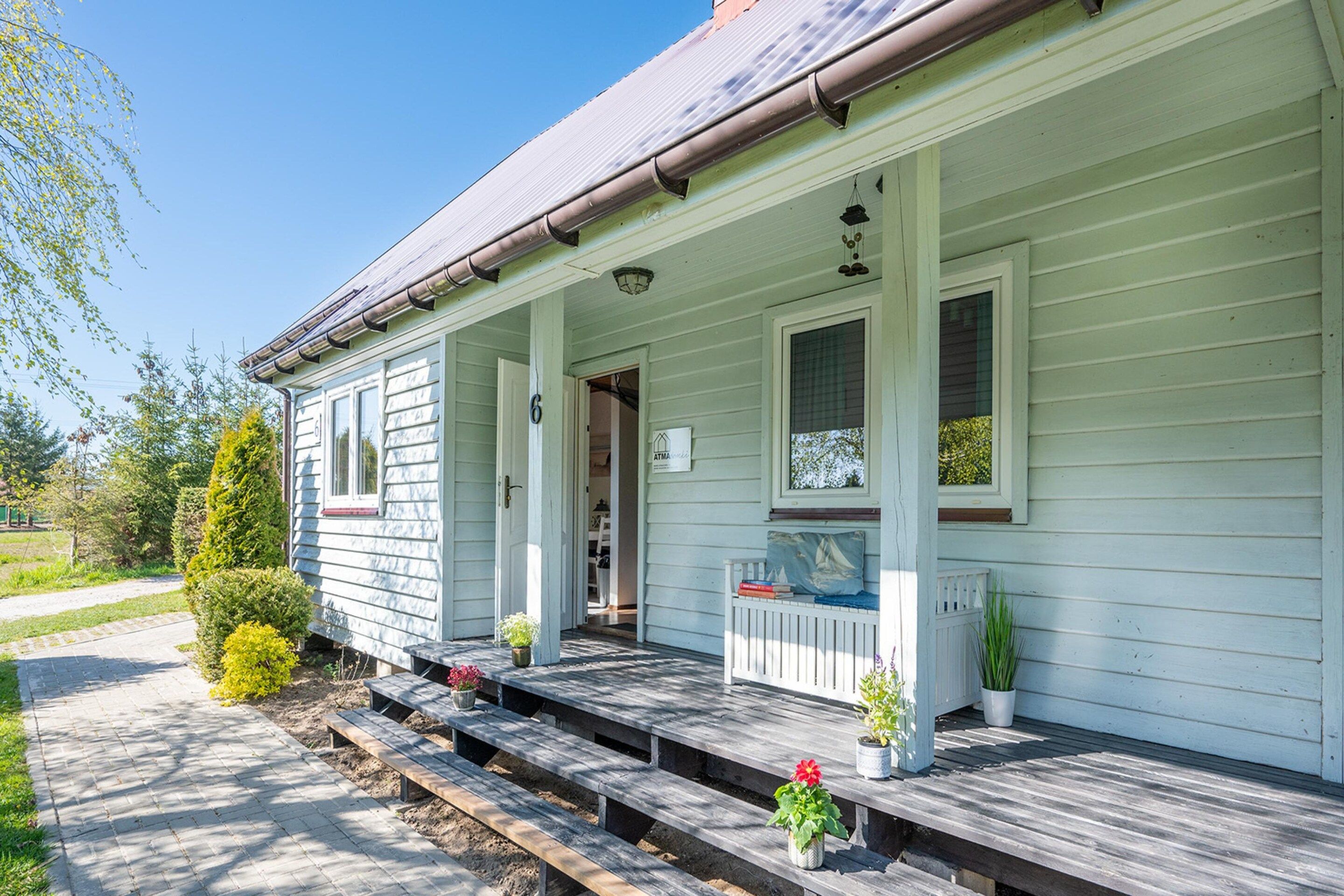 A single-story house with a porch, a mailbox, and a small garden area.