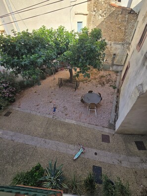 Ein Innenhof mit Baum, Bank und Tisch.