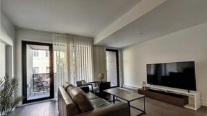Uma sala de estar moderna com sofá, mesa de centro e televisão de tela plana.