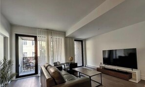 Ein modernes Wohnzimmer mit Sofa, Couchtisch und Flachbildfernseher.