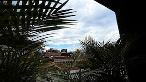 A view of buildings with red-tiled roofs and a cloudy sky. - Oasis Penthouse Poblado (Medellín)