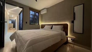 Een moderne slaapkamer met een groot bed, een nachtkastje en een raam.