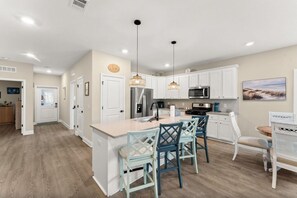 A modern kitchen with white cabinets, a central island with bar stools, and pendant lighting. - Wonderful 3-bedroom townhome with AC in Port St. Joe (Port St. Joe)